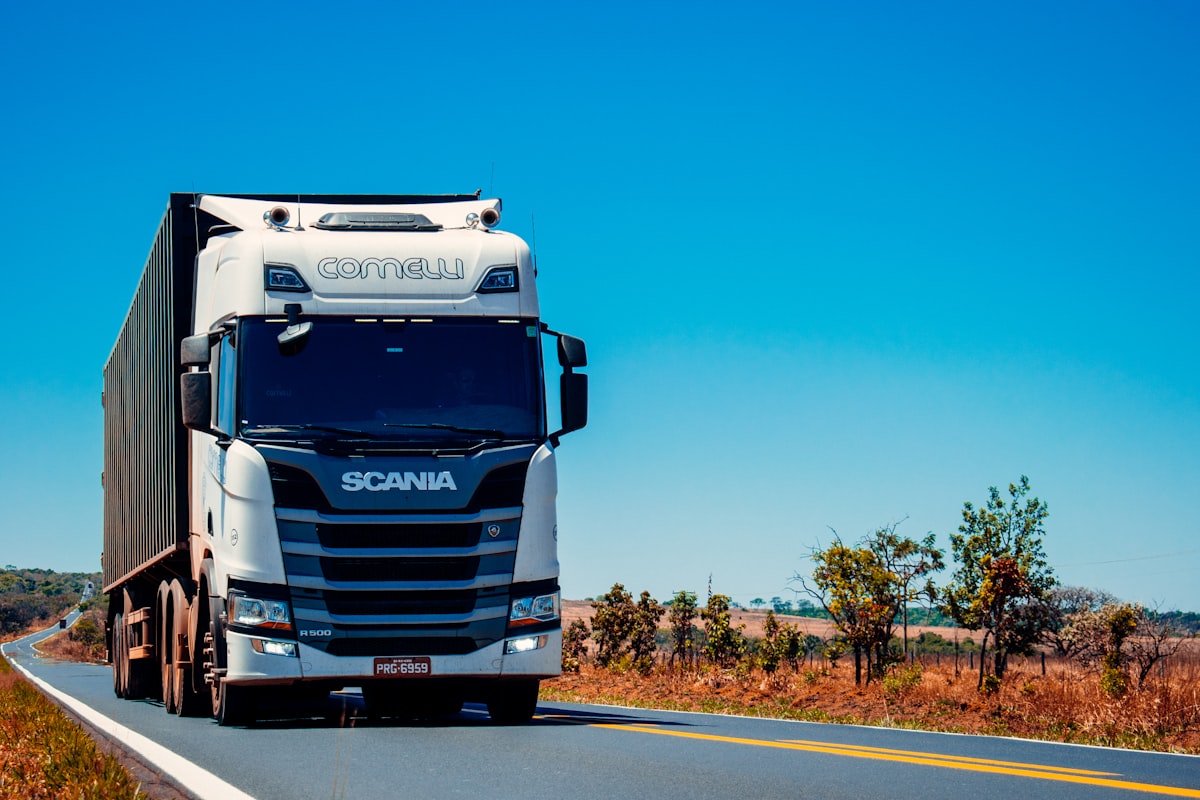 Semi-truck with container on highway under blue sky